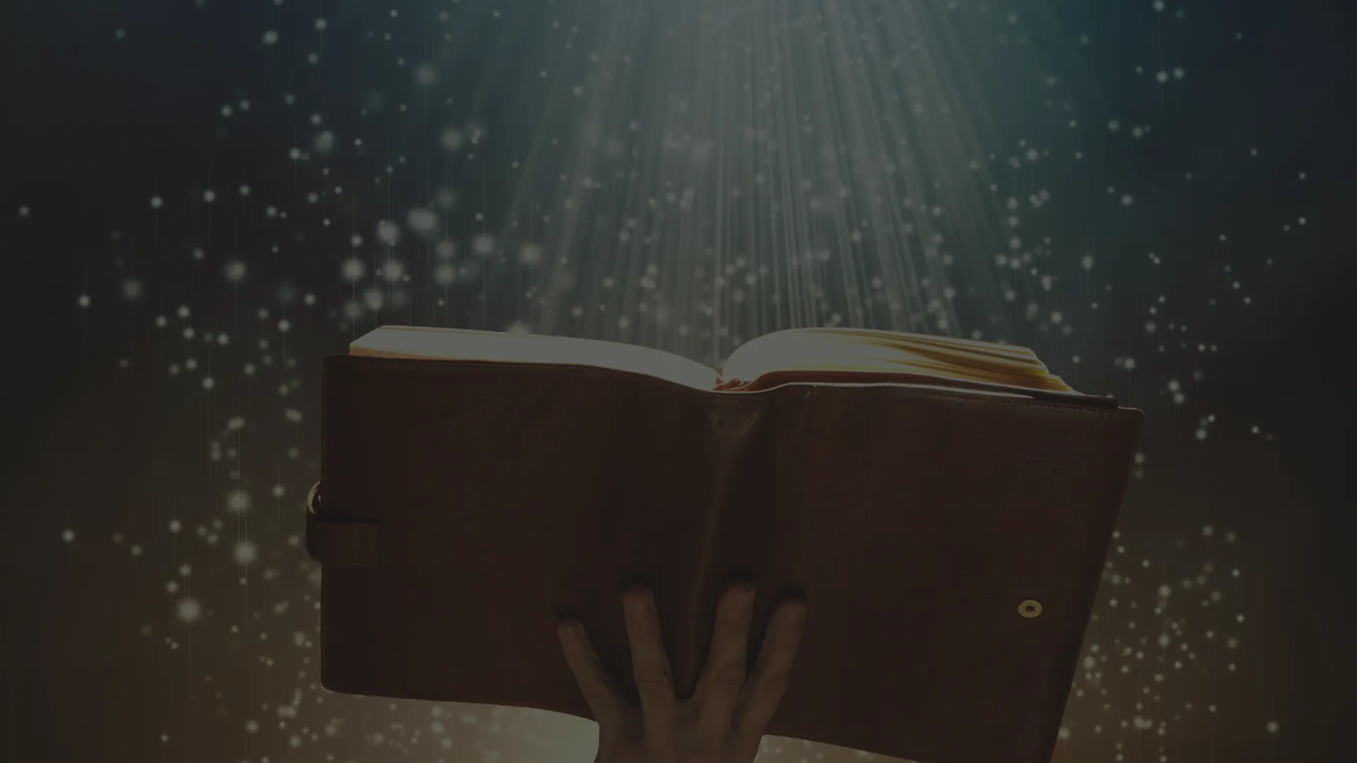 Une main tient un livre ouvert sous une lumière scintillante, symbolisant un univers narratif.